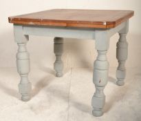 An early 20th Century oak draw leaf dining table raised on cup and cover supports united by