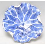 An Oriental blue and white bowl in the form of a lotus leaf with fanned edges having an applied