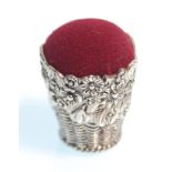 A stamped 925 silver pin cushion in the form of a basket having raised floral decoration with a