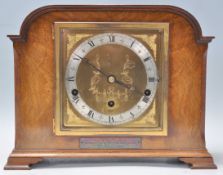 A good early 20th Century Art Deco Elliott oak and walnut cased mantel clock having a brass face