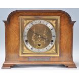 A good early 20th Century Art Deco Elliott oak and walnut cased mantel clock having a brass face