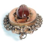 A 19th Century Victorian brooch of ovular form decorated with a beetle set with a red stone and