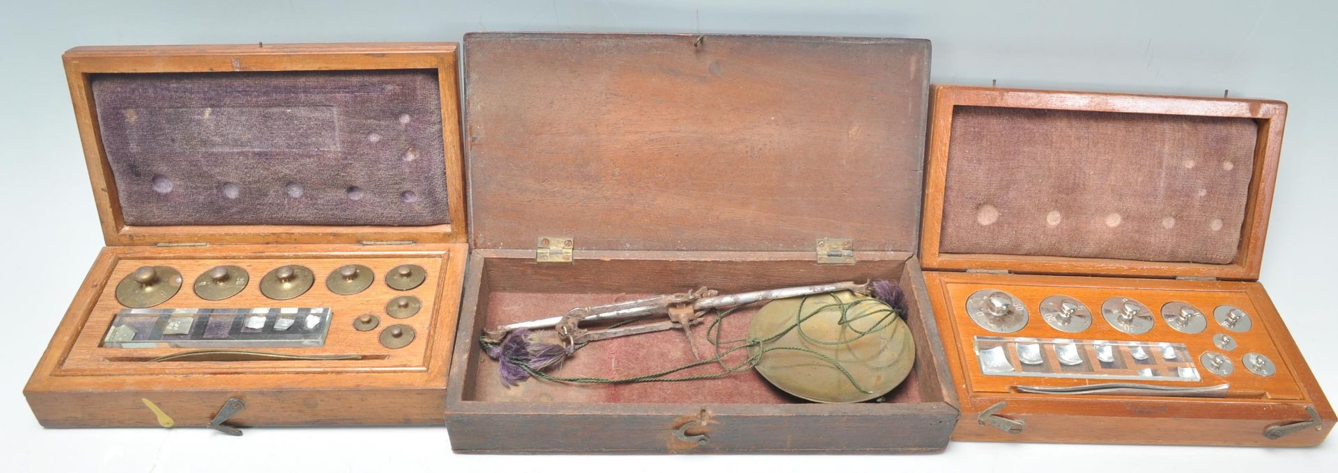 An early 20th Century mahogany cased set of portable brass scales together with two cased sets of