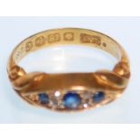 A early 20th Century hallmarked 18ct gold ring set with three round cut sapphires with four small