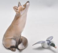 A Royal Copenhagen figurine of a fox with a upturned nose (no. 1475) together with a small