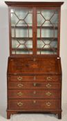 A George III 18th century mahogany and marquetry inlaid cross-banded bureau bookcase. Raised on