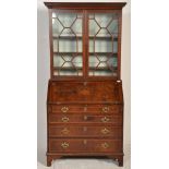 A George III 18th century mahogany and marquetry inlaid cross-banded bureau bookcase. Raised on