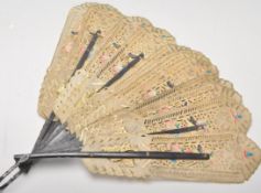 An early 20th century hand fan having ebonised ribs with paper leaves having pierced decoration