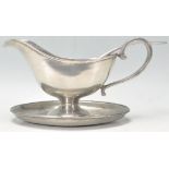 An early 20th Century French good quality pewter sauce boat and stand. Together with a matching