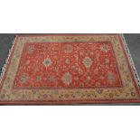 A vintage 20th Century machine woven Persian floor rug having a red ground and cream ground border