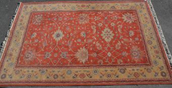 A vintage 20th Century machine woven Persian floor rug having a red ground and cream ground border