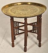 A vintage 20th Century Indian / Middle Eastern brass topped Binares occasional table having engraved
