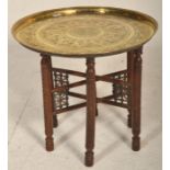 A vintage 20th Century Indian / Middle Eastern brass topped Binares occasional table having engraved