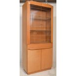 A 20th century Danish Skovby light oak modernist display cabinet. Raised on a plinth base with