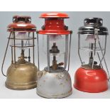 A collection of early 20th century Tilley lamps to include grey, gold and red enamel painted