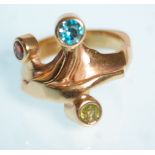 An unusual 9ct yellow gold ring set with a red, green and blue round cut stones set to a