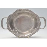 An early 20th Century Art Nouveau twin handled pewter tray having repousse floral decoration.