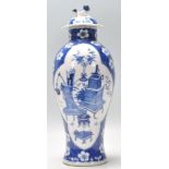 A 19th Century blue and white lidded vase being hand painted in the prunus pattern with a central