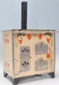 A vintage 20th Century tin model of a stove / oven having a series of doors and drawers to the front