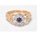 A hallmarked 9ct yellow ladies ring set with a central round facted cut blue stone with a white