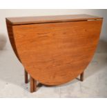 A retro 1970's teak wood Danish influenced G-Plan drop leaf dining table raised on shaped supports