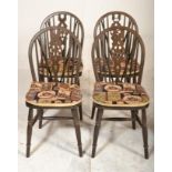 A set of four 20th Century wheelback dining chairs raised on turned legs united by H stretchers
