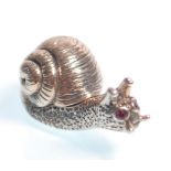 A stamped sterling silver figurine / miniature box in the form of a snail having red stone eyes, the