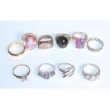 A group of ten silver rings to include a ring set with a large faceted white stone, a three stone
