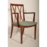 A 20th Century carver arm chair having a teak wood frame with pierced bowed wooden design back rest,