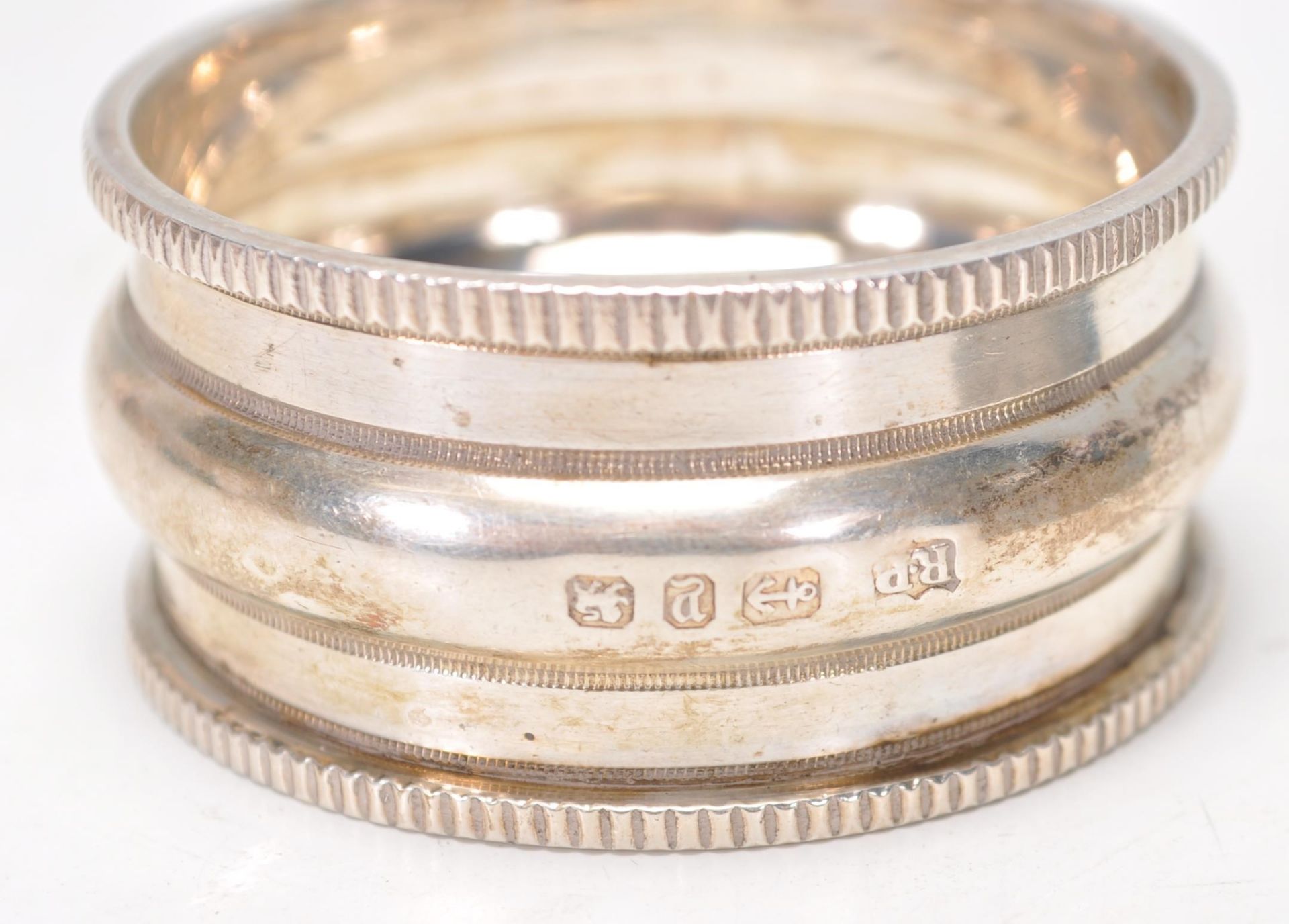 A group of four silver hallmarked napkin rings to include a napkin ring with gadrooned border ( - Image 3 of 6