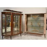 A 1930's Art Deco display cabinet with mirror back and unusual gallery top above all raised on