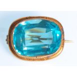 A Victorian 9ct gold ladies brooch set with a large faceted cut blue stone and rope twist