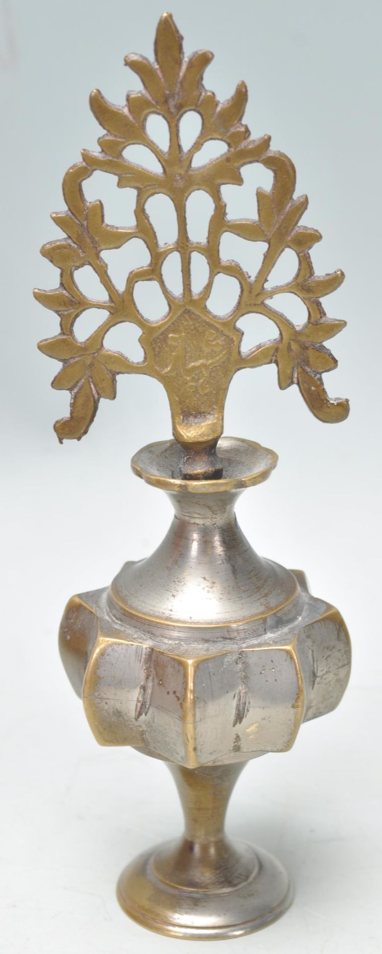 An early 20th Century Chinese brass scent bottle having a fret priced stopper and angular star body.