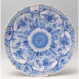 An 18th Century blue and white Delft wall charger plate of round form, being hand painted with