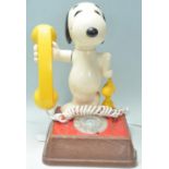A vintage 1970's novelty Snoopy telephone having a wooden base with a number dial to the front