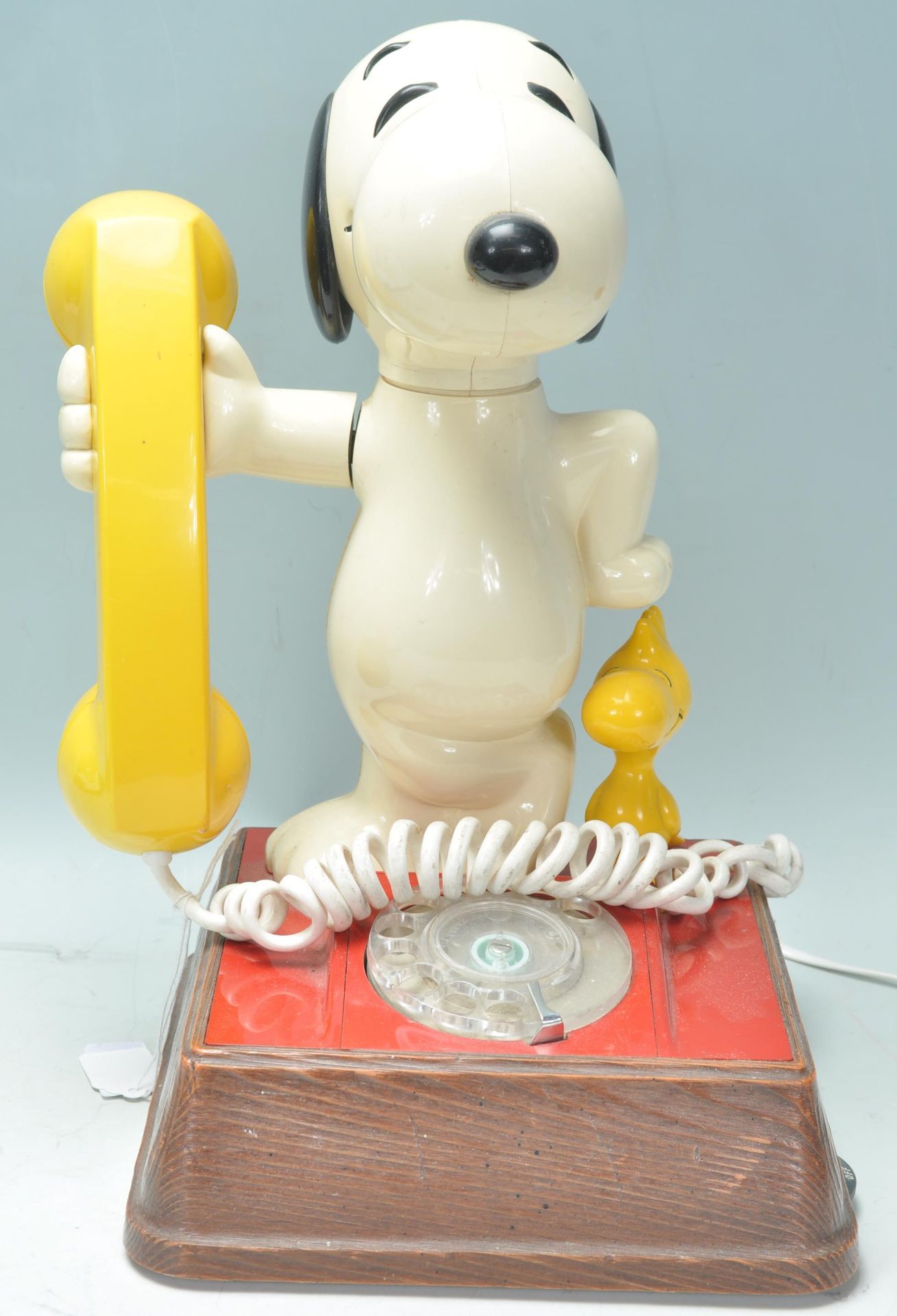 A vintage 1970's novelty Snoopy telephone having a wooden base with a number dial to the front