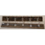 Two good pairs of five ( ten in total ) wall hanging chrome coat hooks mounted onto wooden strips.