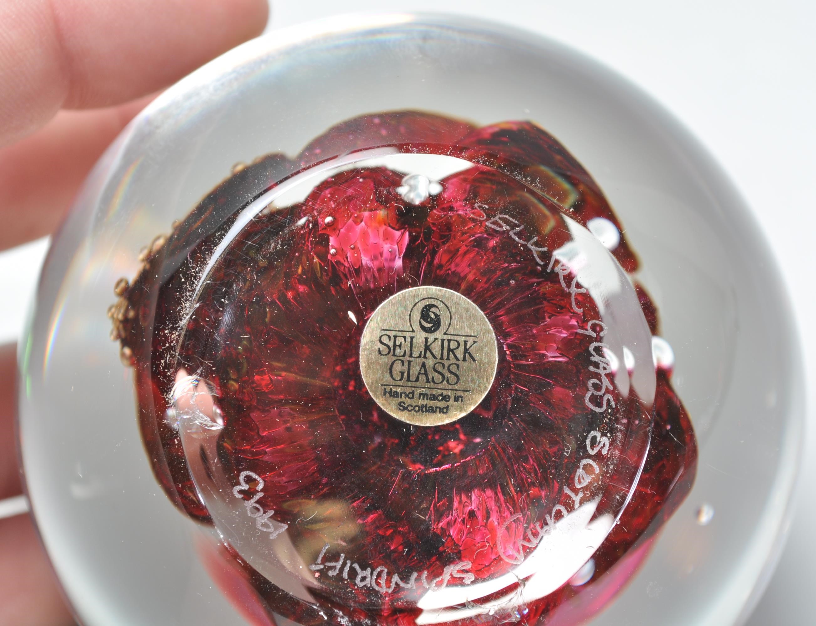 A group of four paper weights to include a Selkirk Scottish paper weight of red swirl design (signed - Image 6 of 7