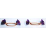 A pair of antique gold and amethyst cufflinks having oval cut amethysts united by gold connectors.