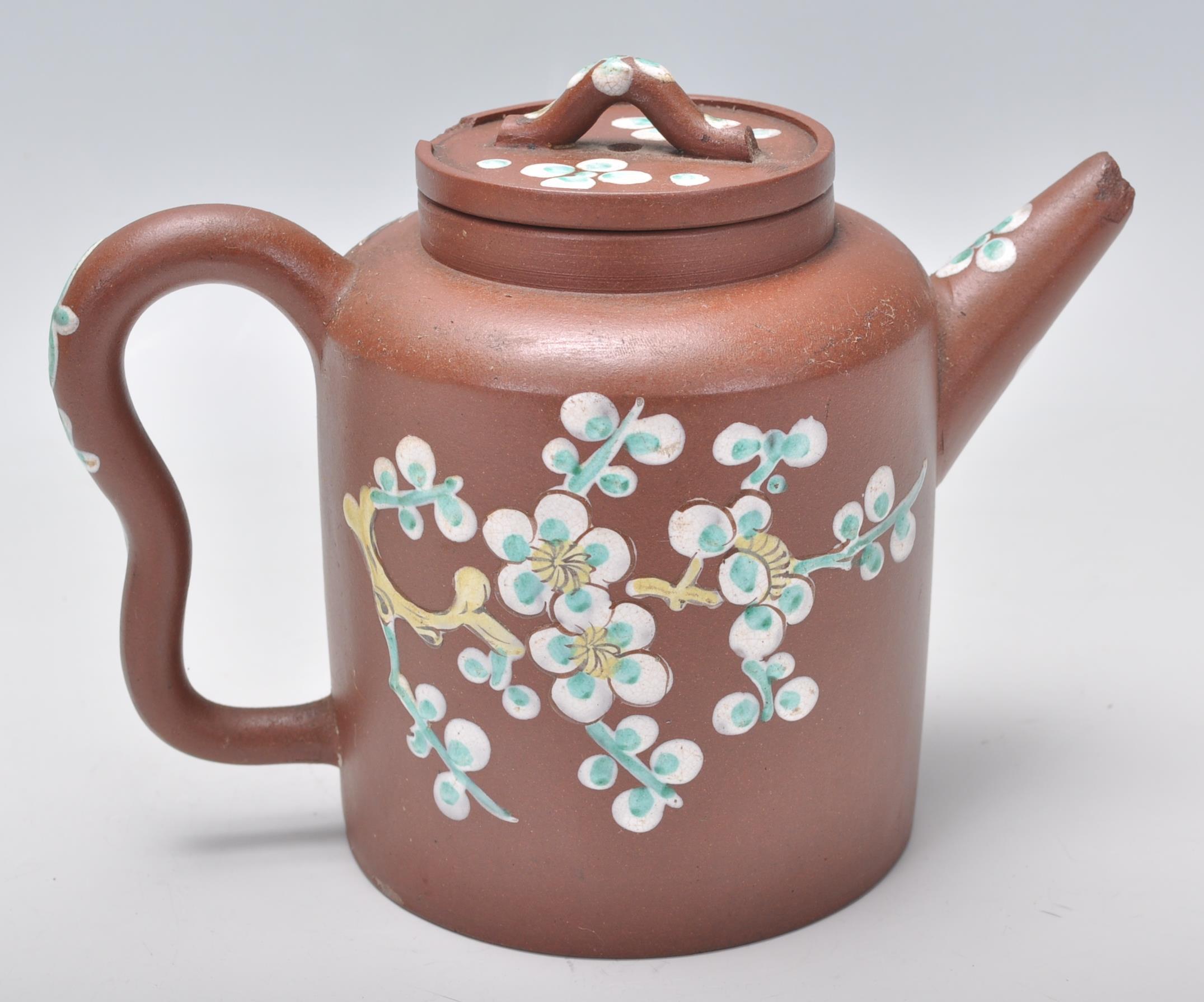 An early 20th Century Chinese brown clay teapot having hand enameled bird and floral decoration with