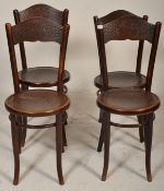 A set of four vintage 20th Century thonet style cafe dining chairs having round seats with impressed