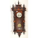 A 20th Century Vienna regulator wall clock having turned columnal supports, with a carved decoration