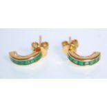 A pair of 18k yellow gold half hoop earrings set with faceted square cut emeralds. Stamped 18k.