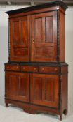 A Victorian mahogany 19th century double panelled livery cupboard / bookcase decorated with