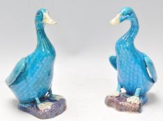 Two mid 20th Century Chinese ceramic duck figurines having a turquoise glaze, raised on naturalistic