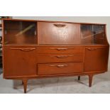 A retro 20th Century teak wood Danish influence highboard sideboard credenza, being raised on