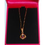 An 18ct gold pendant necklace having a tear drop pendant set with a round cut ruby and diamond.