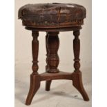 A Victorian 19th century mahogany and leather revolving piano stool. Raised on ring turned legs with