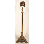 A 19th Century Victorian free standing oil lamp raised on a round base with three shell formed feet,