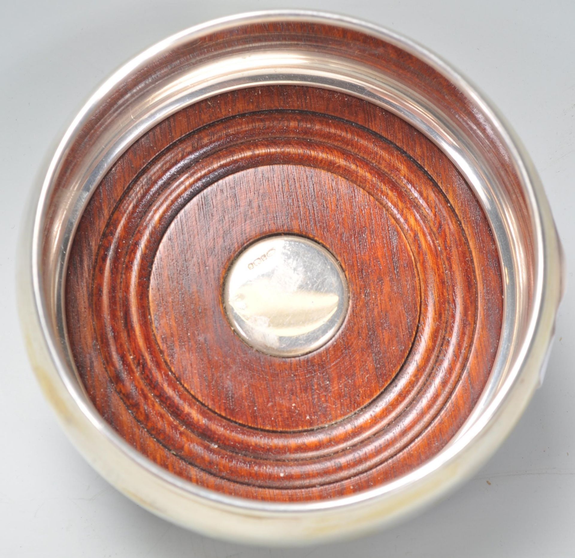 A good silver hallmarked wine coaster having a round bulbous body raised on a wooden base. - Image 4 of 7